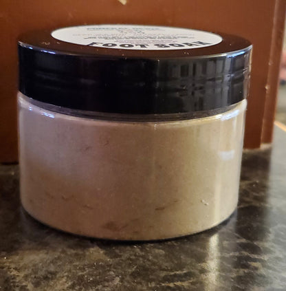 Jar of foot soak on a marble surface with a brown background