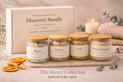 The Bath Apothecary Discovery Bundle Master Collection with jars labeled 'Reset', 'Renew', 'Glow', and 'Ritual Comfort' on a wooden board.