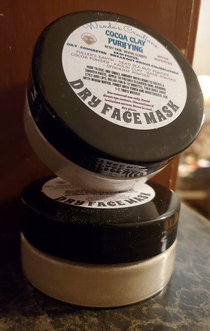 Two containers of Dry Face Mask with labels on a marble surface.